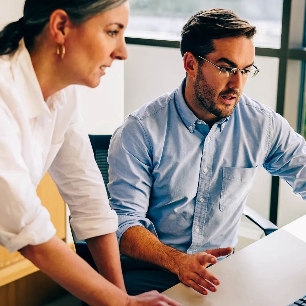 Office workers working together on laptop