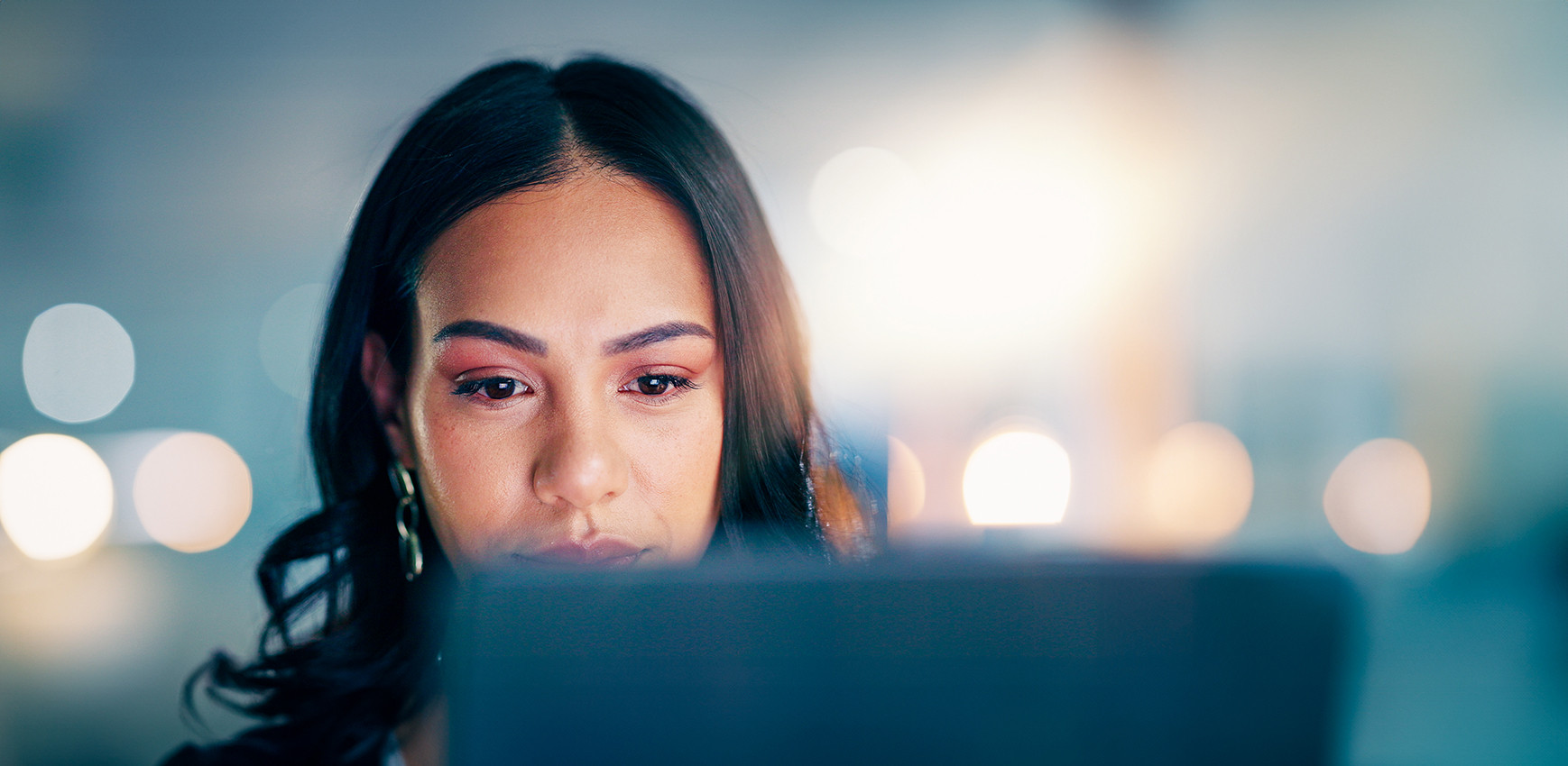 Office professional working attentively on a computer in a low-light office setting