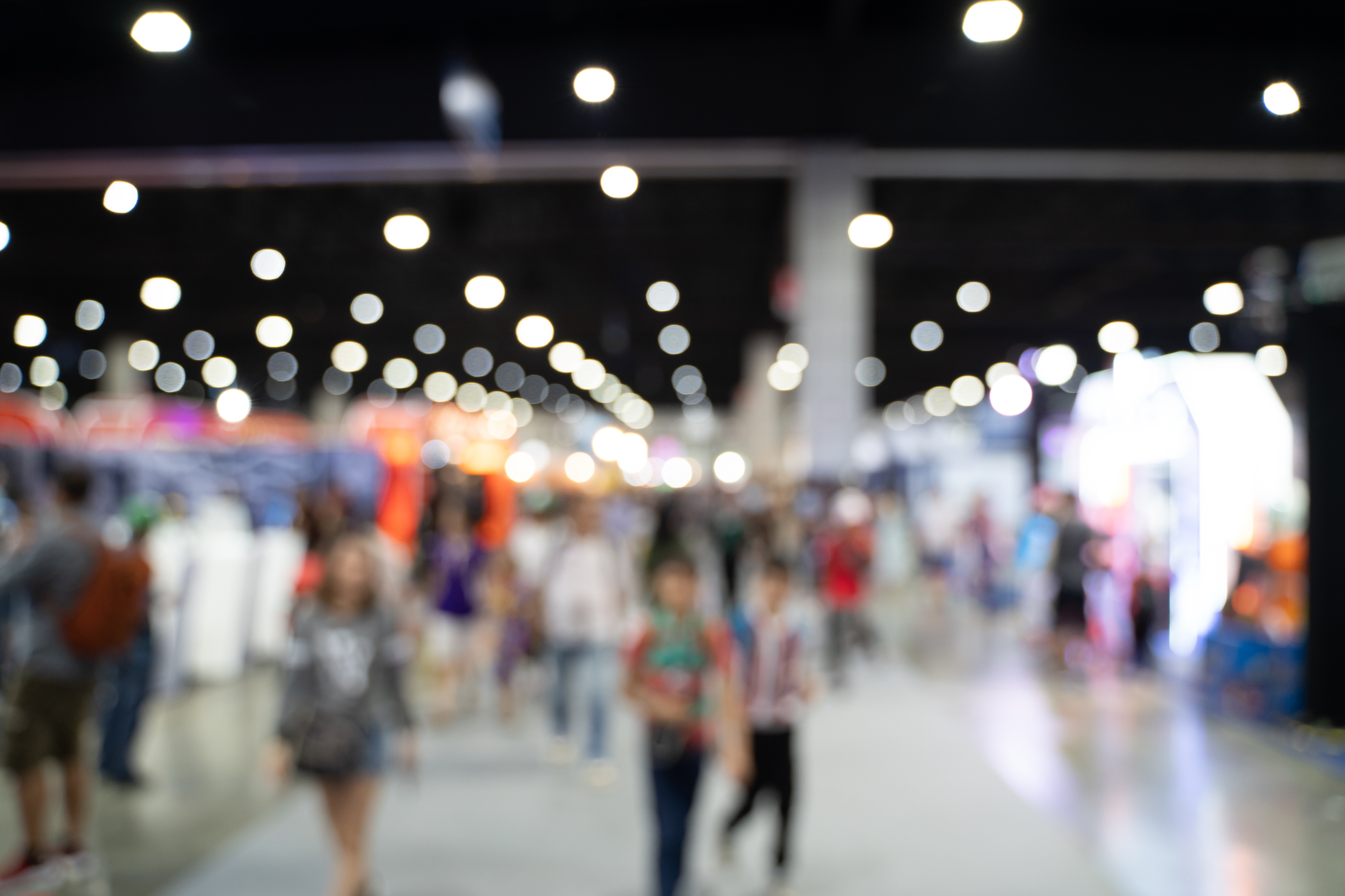Blurred images of trade fairs in the big hall. image of people walking on a trade fair exhibition or expo where business people show innovation activity