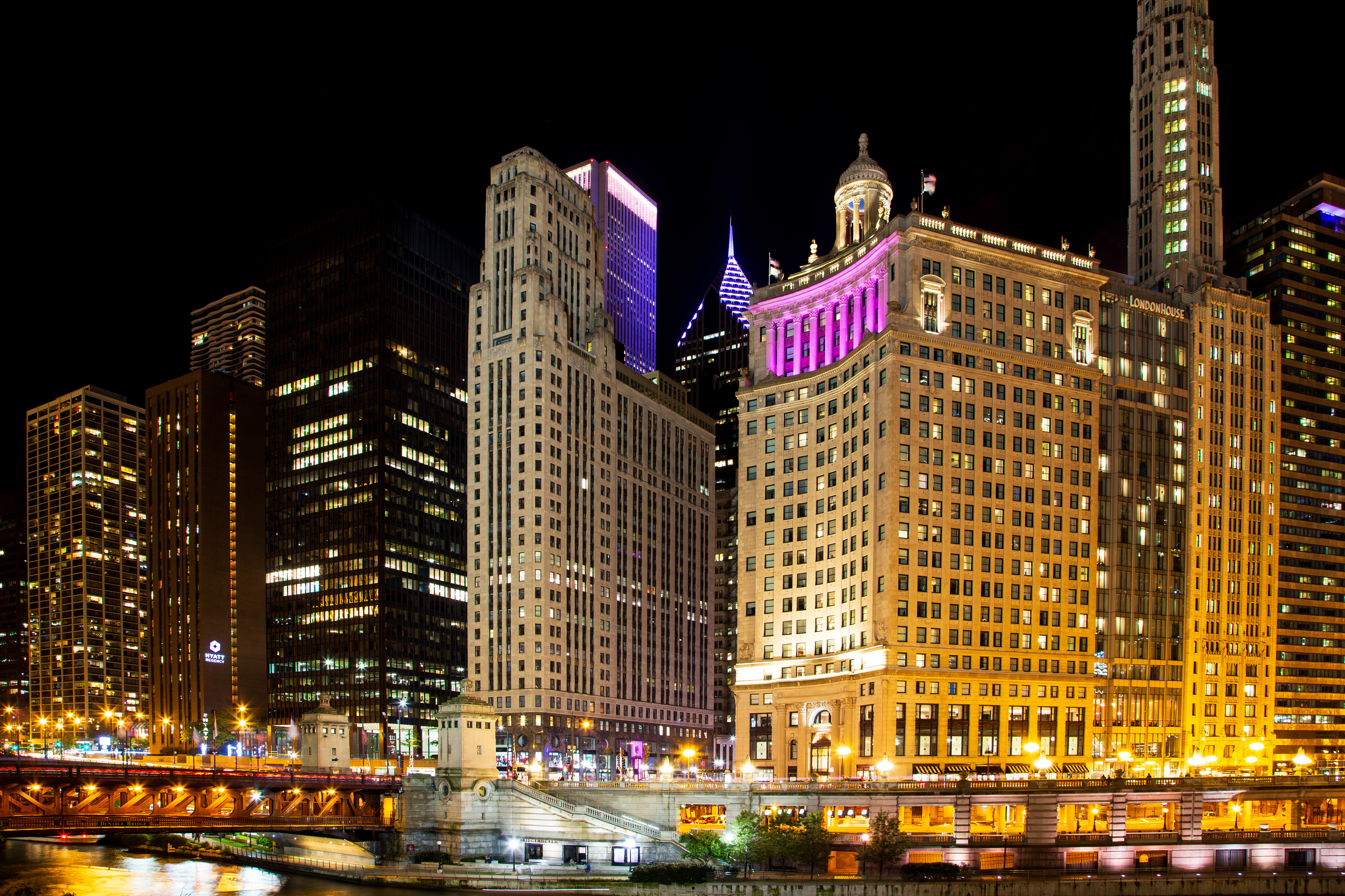 Chicago, Illinois, USA, October 1, 2024 - The Hyatt Regency Chicago, the London House and other buildings on Wacker Drive along the river seen illuminated at night
