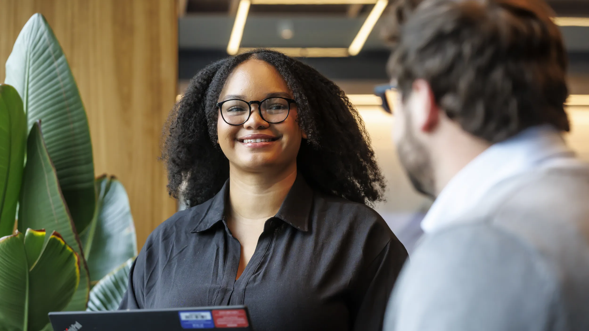 Professional collaborating with a colleague in a modern workplace using technology to support healthcare operations and revenue cycle performance