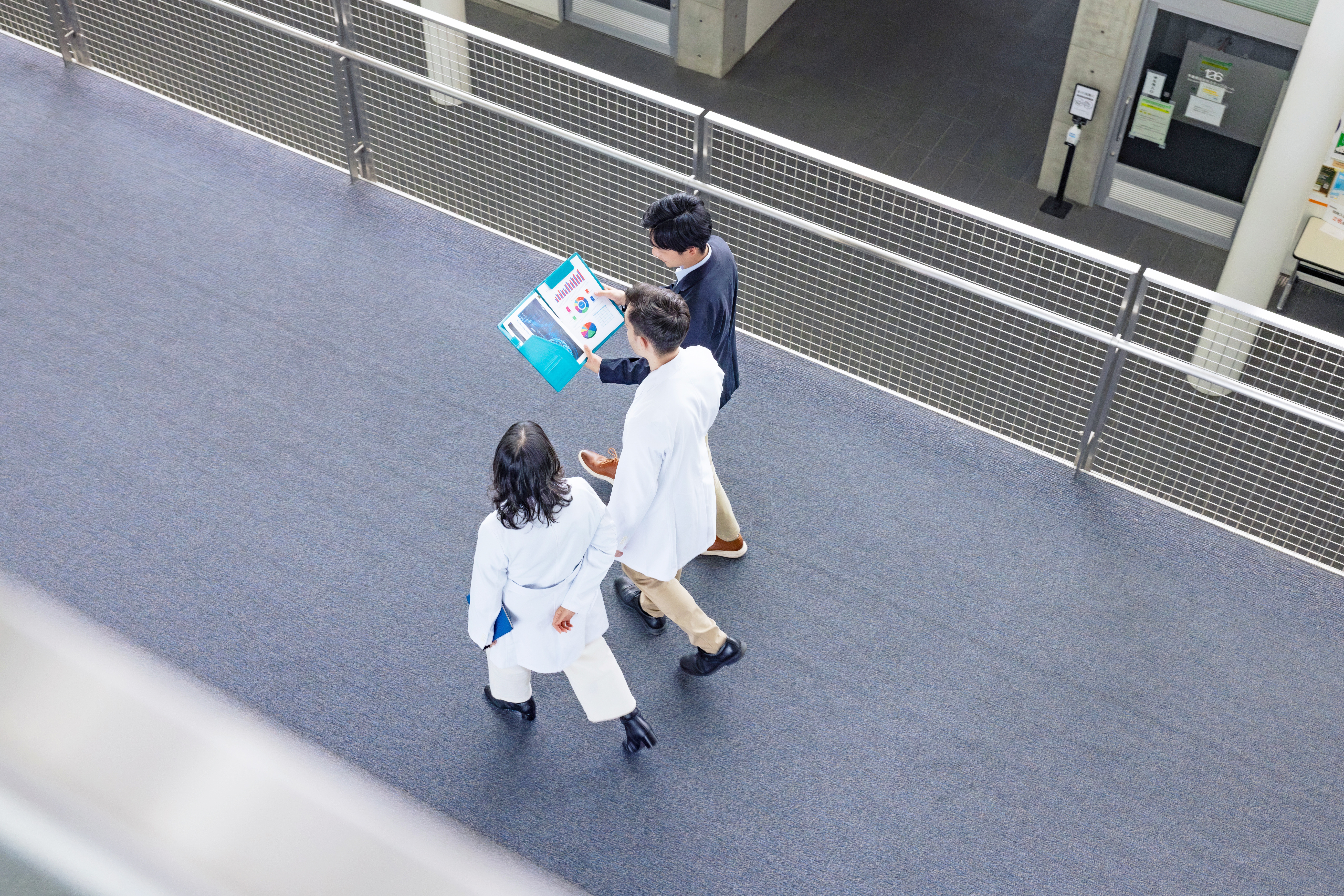 Healthcare professionals reviewing performance reports while walking through a hospital corridor