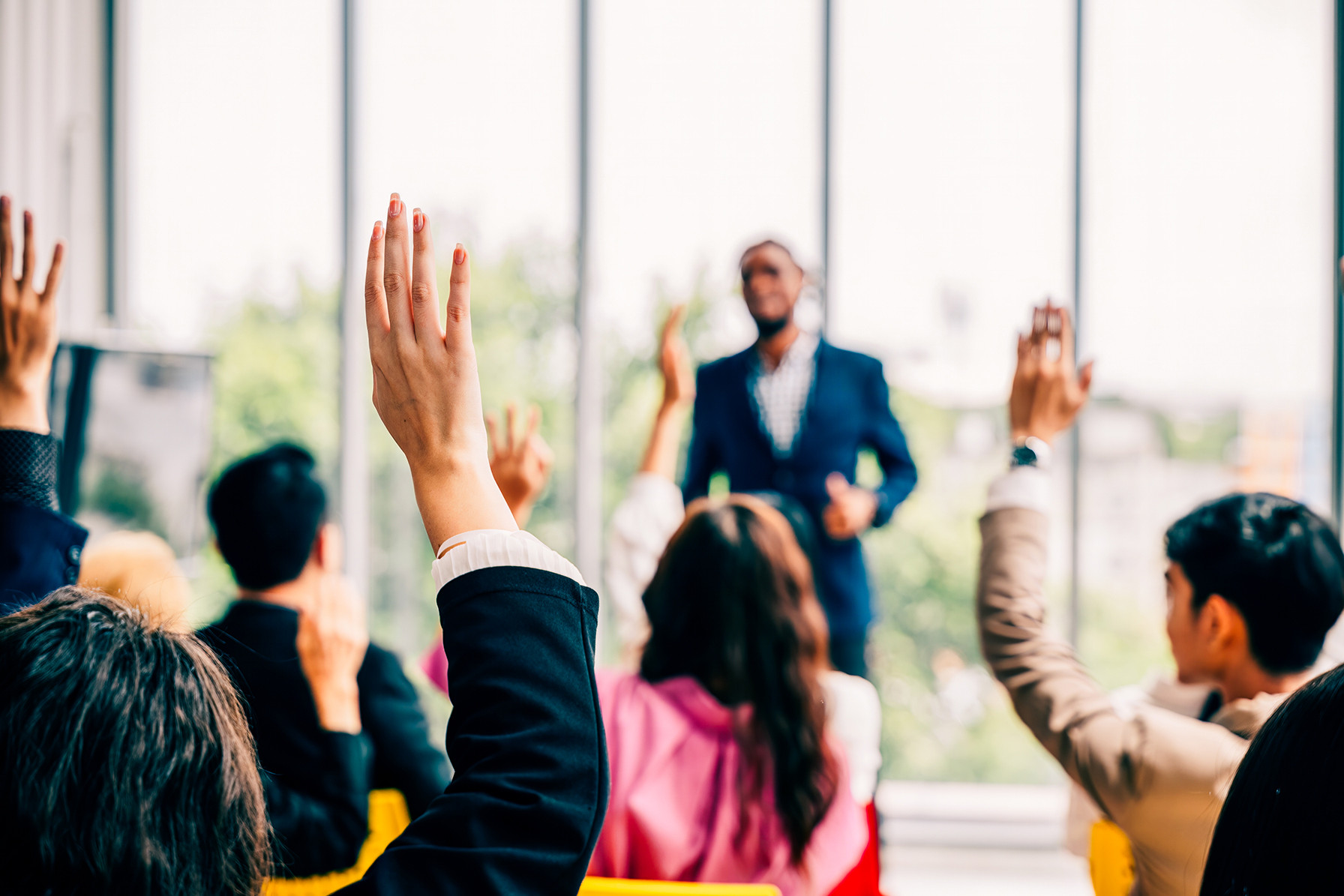 People raising their hands during a presentation or training session.