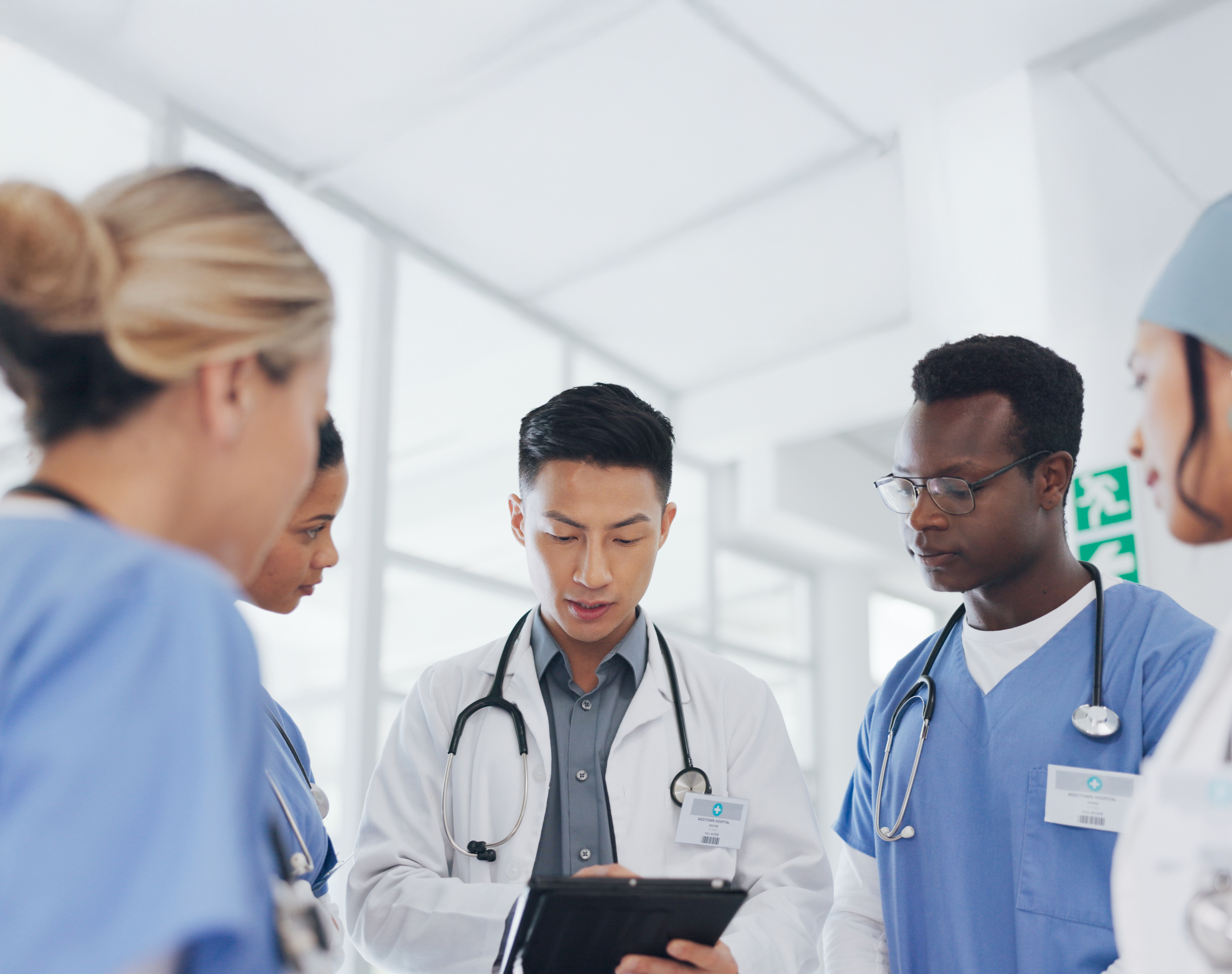 Clinical team using a tablet to access patient records in a modern healthcare facility.