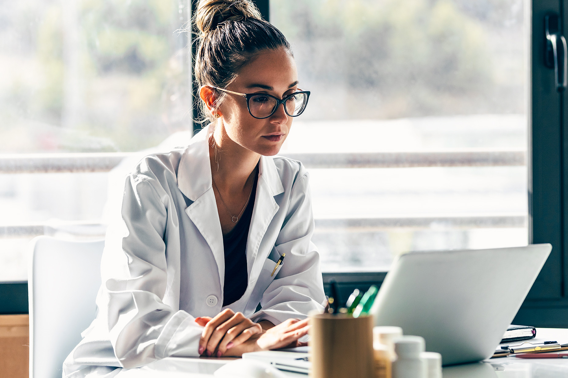 Healthcare professional reviewing information on a laptop to support clinical decision-making, care coordination, and operational efficiency