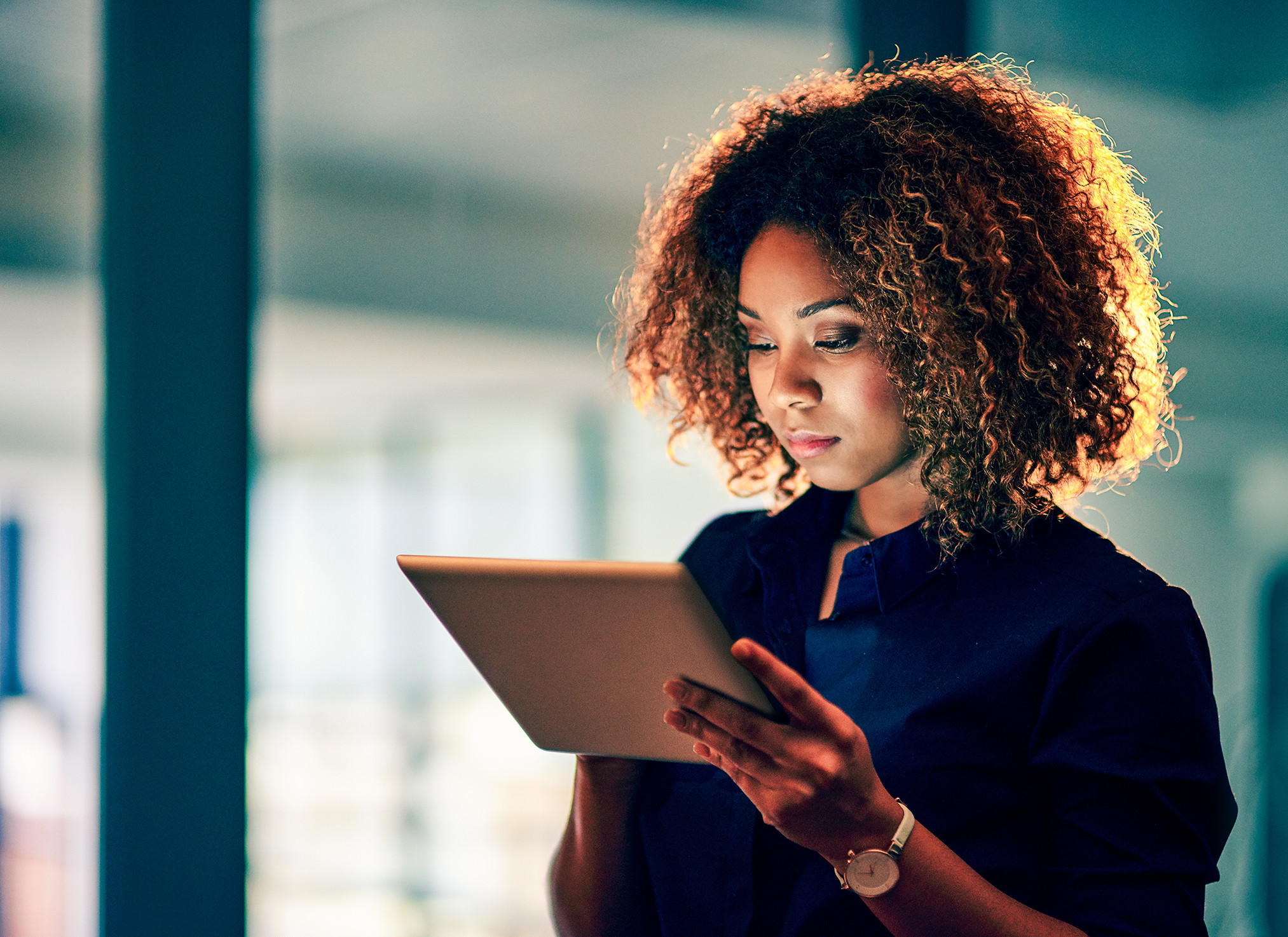 Working smart, working hard. Shot of a young businesswoman using a digital tablet during a late night at work.