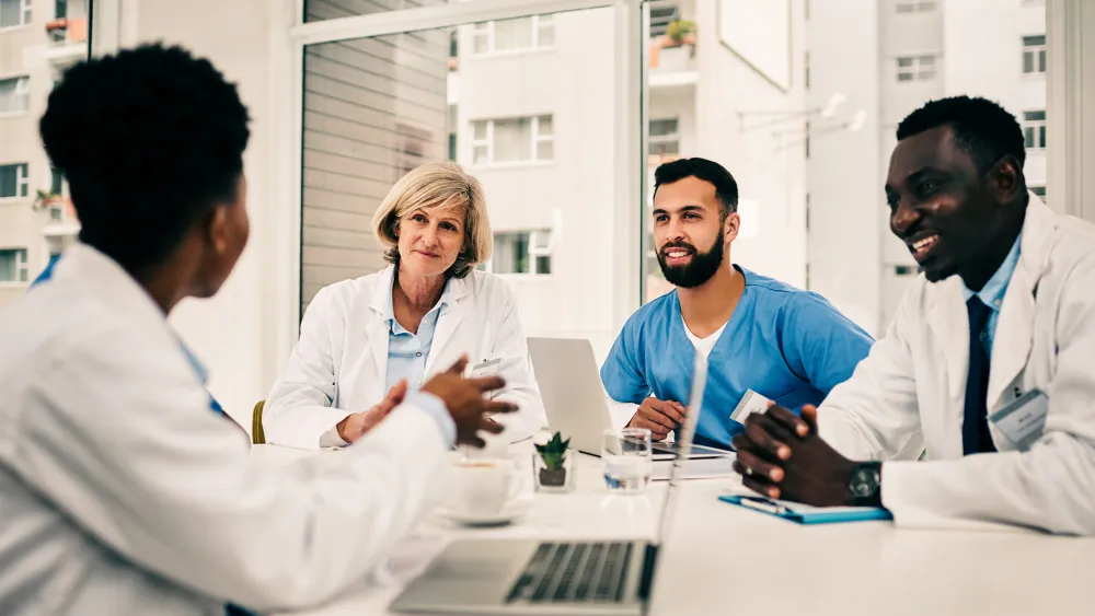 Healthcare professionals collaborating in a team meeting to improve operational performance, patient outcomes, and revenue cycle management