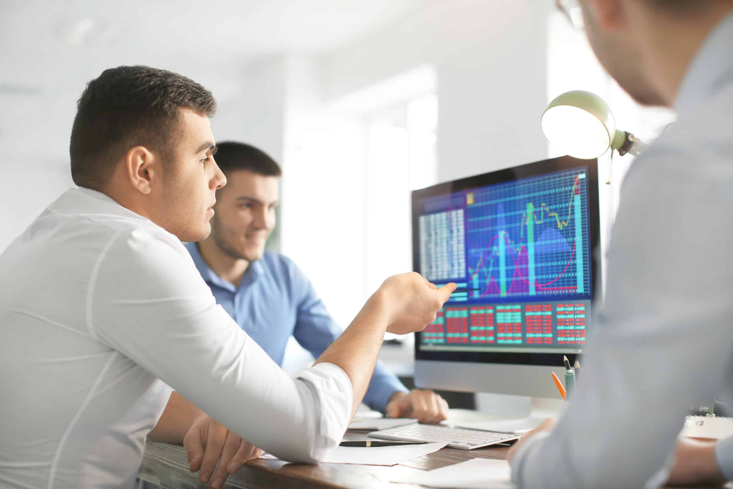Business professionals analyzing financial data on a computer screen, reviewing charts and performance metrics to support data-driven decision-making.