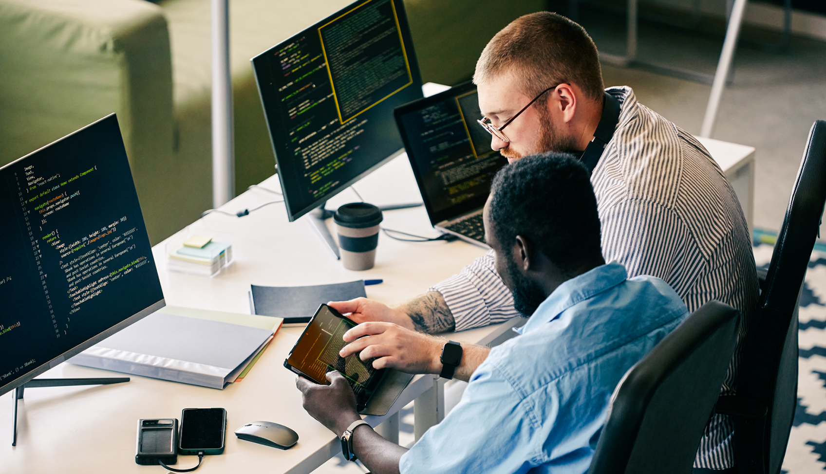 Developers collaborating on code and data systems across multiple screens to build AI-driven solutions and improve operational performance.