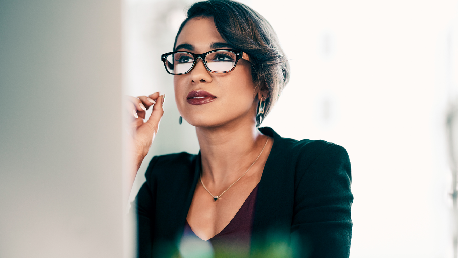 Healthcare technology leader reviewing information on a computer in a modern office setting.