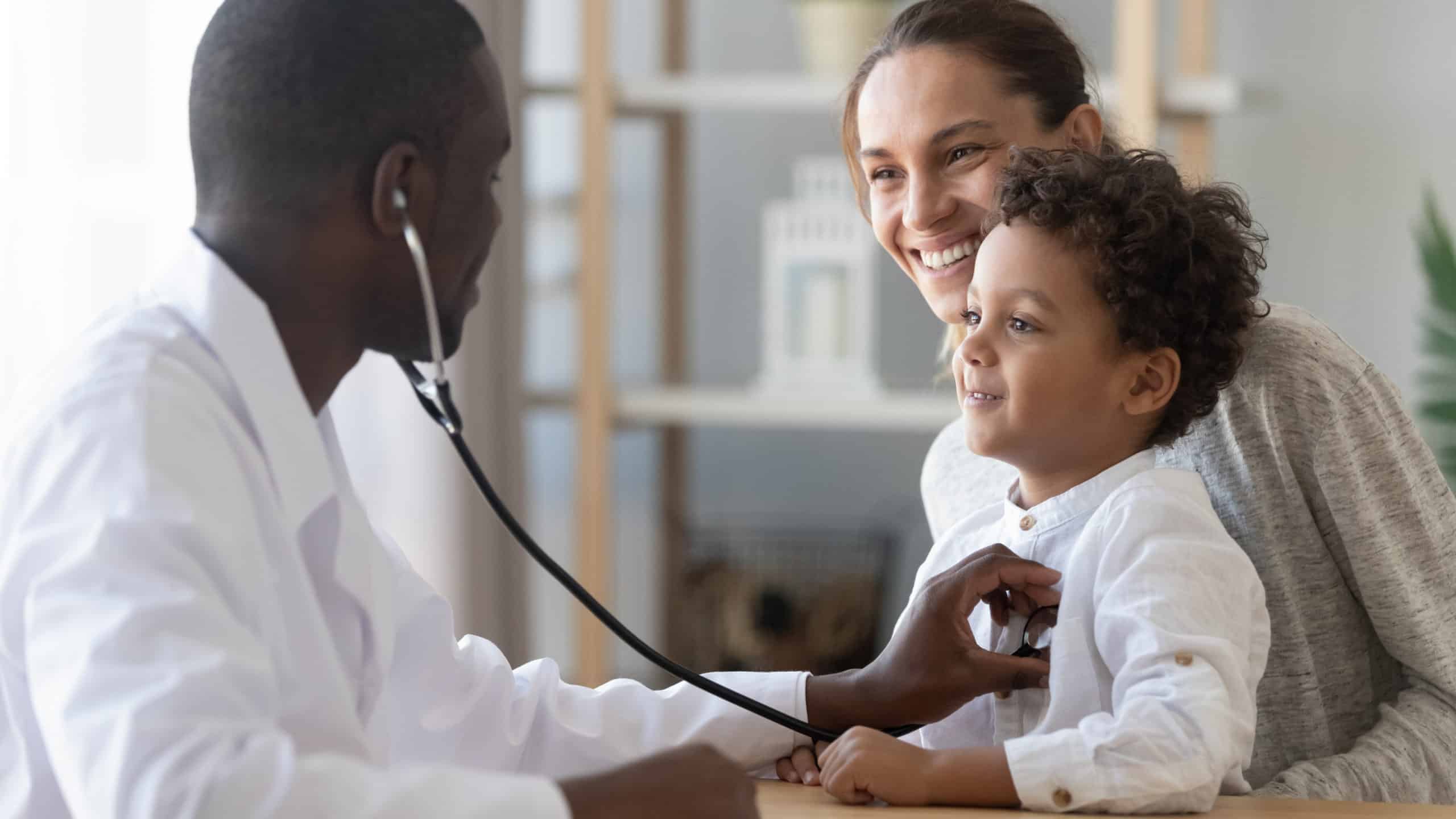 African male pediatrician hold stethoscope exam child boy patient visit doctor with mother