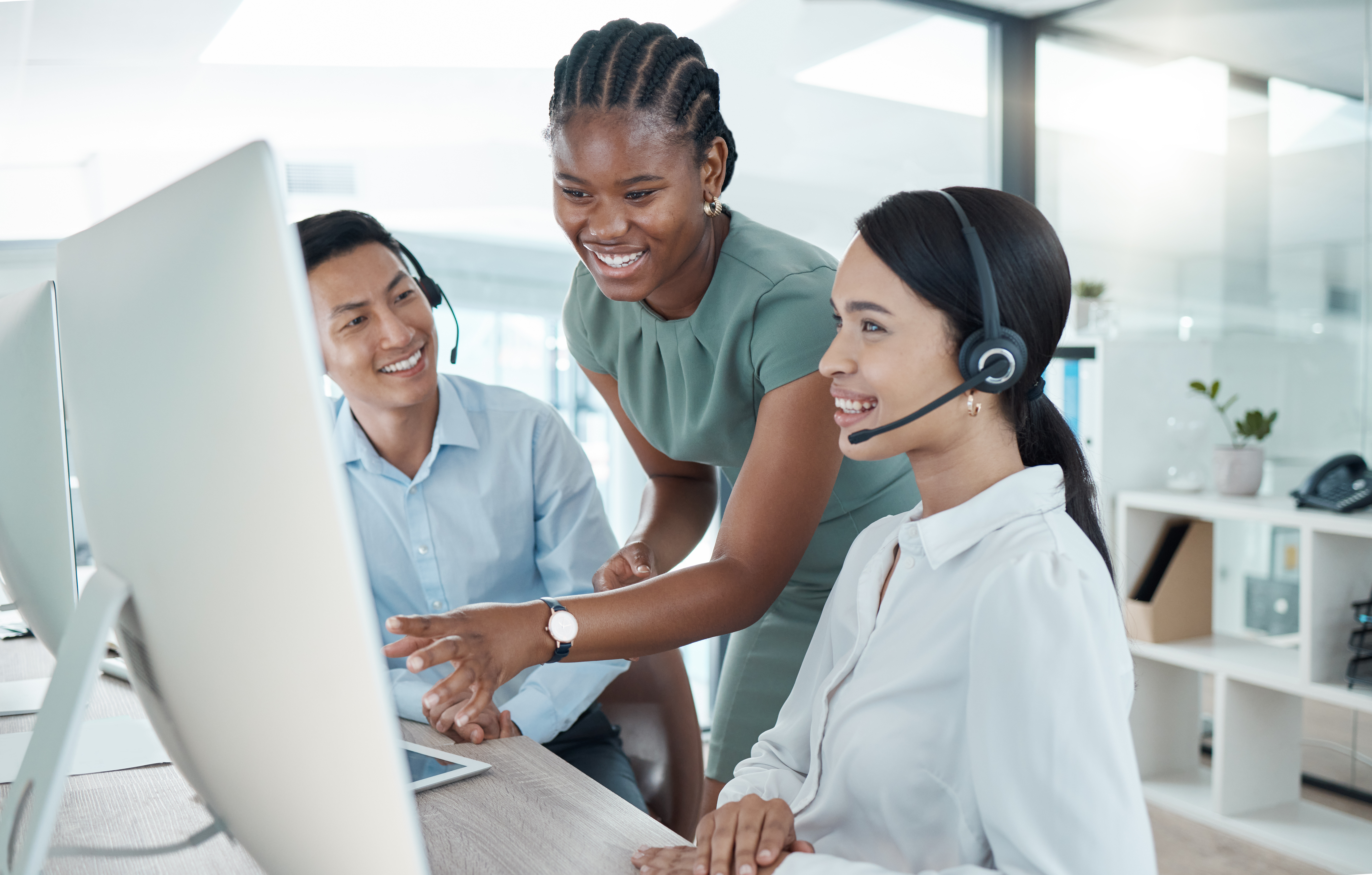 Crm, call center and computer with training, team and smile at office for learning with manager. Man, woman and diversity in education in customer service, help and support at agency in telemarketing