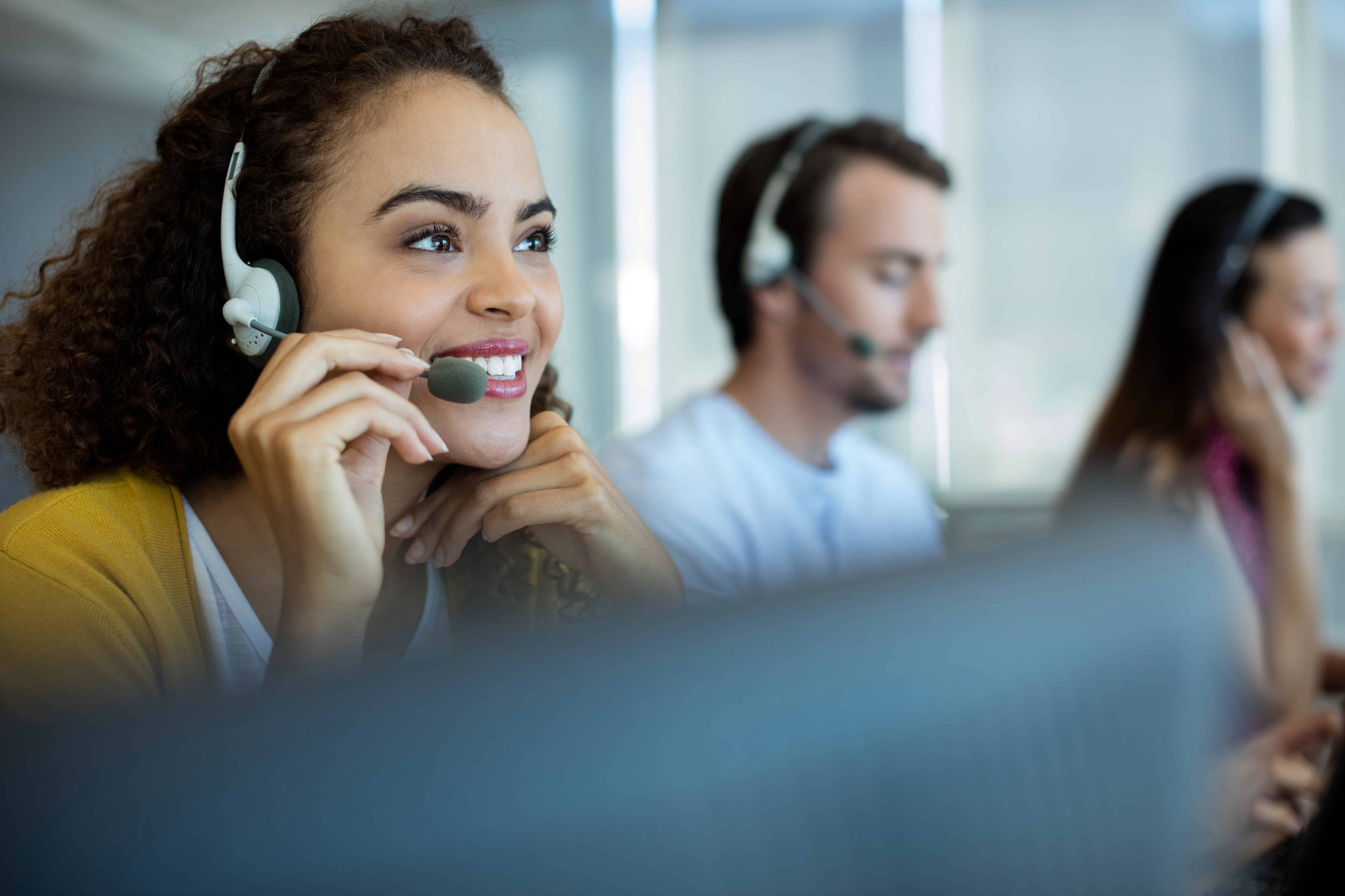 Woman in a call center smiling talking on a headset