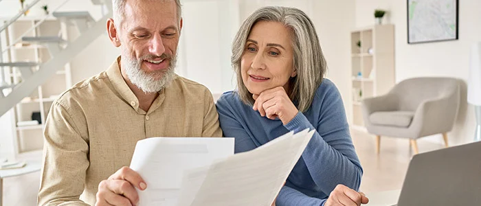 A man and woman looking at billing statement papers.